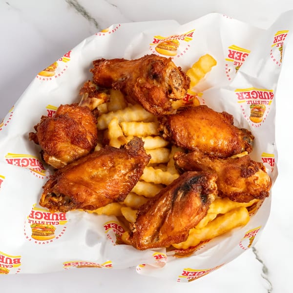 Cali Style Burger's fried chicken wings and crinkle-cut fries in a branded paper-lined basket.